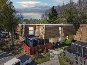 Charming townhouse featuring a fenced yard and distinctive wood shake roof at 12738 Wood Trail Blvd, Tampa, FL 33625