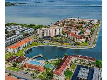 Stunning aerial view of waterfront condos, a pool, and the bay in a vibrant community at 19029 Us Highway 19 N # 12E, Clearwater, FL 33764