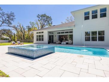 A gorgeous backyard pool and spa offer a luxurious outdoor space with sunny lounge area at 2216 Clement Rd, Lutz, FL 33549