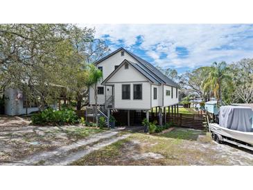 Stilt house with a driveway, boat, and a well-maintained yard and landscaping at 3327 Pineview Dr, Holiday, FL 34691