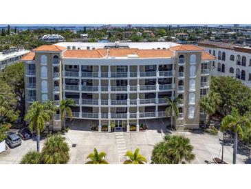 Stunning condo building featuring a terracotta roof, white accents and multiple levels of balconies overlooking lush landscaping at 3805 Gulf Blvd # 404, St Pete Beach, FL 33706