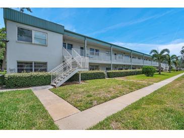 Well-maintained condo exterior featuring multiple units, landscaped grounds, and stair access to upper levels at 5267 81St N St # 18, St Petersburg, FL 33709