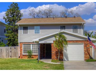 Charming two-story home with a brick facade, well-manicured lawn, and an American flag at 531 Luzon Ave, Tampa, FL 33606