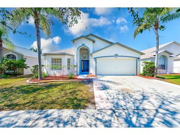 Charming one-story home with attached two-car garage and tropical landscaping at 12821 Lake Vista Dr, Gibsonton, FL 33534