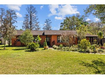 Charming single-story home with a well-manicured lawn, lush landscaping, and beautiful curb appeal at 17119 Rainbow Ter, Odessa, FL 33556