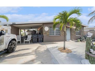 Charming single-story home featuring a covered carport, mature landscaping, and a welcoming entrance at 265 115Th Ave, Treasure Island, FL 33706