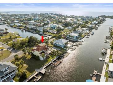 Stunning aerial view of a waterfront community with lush landscaping and canal access to the open bay and Gulf of Mexico at 3447 Flamingo Blvd, Hernando Beach, FL 34607