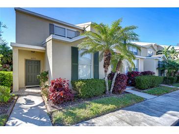 Charming two-story townhome featuring a manicured front yard, lush landscaping, and a welcoming front door at 6255 Osprey Lake Cir, Riverview, FL 33578