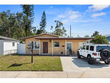 Charming single-story home features a well-maintained lawn, a white jeep, and a cozy covered porch at 350 51St N Ave, St Petersburg, FL 33703