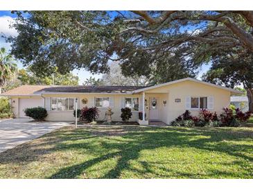 Charming single-story home with manicured lawn and mature trees in a desirable neighborhood at 1549 San Christopher Dr, Dunedin, FL 34698