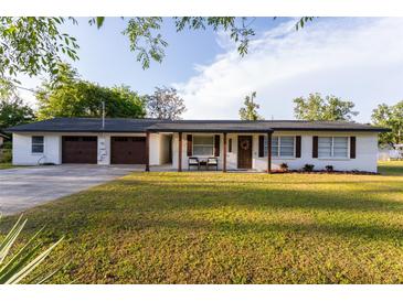 Charming single-story home with white painted brick, wood shutters, and a well-manicured front lawn at 38811 Inez Ave, Zephyrhills, FL 33542