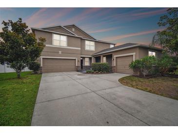 A charming two-story home with a spacious three-car garage and well-manicured landscaping at 501 Washita Stone Dr, Ruskin, FL 33570