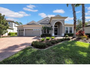 Beautiful one-story home featuring a three-car garage, archway entrance and lush landscaping at 7133 Hatpin Loop, Wesley Chapel, FL 33545