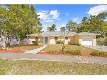 Charming yellow single-story home featuring an attached one-car garage and a well-maintained front yard at 7183 Fireside St, Spring Hill, FL 34606