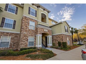 Beautiful condominium building showcasing a stone facade and well-maintained landscaping at 10201 Courtney Palms Blvd # 204, Tampa, FL 33619