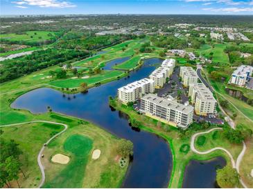 A captivating aerial view of a golf course community featuring waterways and residential buildings at 1200 Country Club Dr # 2206, Largo, FL 33771