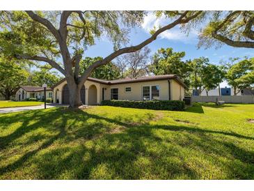 Charming single-story home with a lush green lawn and mature shade trees at 12200 Vonn Rd # 6D, Largo, FL 33774