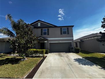 Charming two-story home with landscaped front yard and attached two-car garage at 14618 Scottburgh Glen Dr, Wimauma, FL 33598