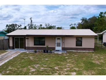 Charming single-story home with metal roof, brick accents, and tidy front yard landscaping at 3751 Cullen St, New Port Richey, FL 34652