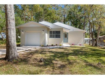 Charming single-story home with a well-maintained lawn and attached one car garage at 411 Virginia Ave, Brooksville, FL 34601