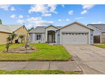 Charming single-story home featuring a two-car garage and well-maintained front yard at 1489 Ridge Shore Dr, Tarpon Springs, FL 34689