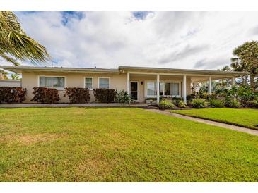 Inviting single-story home with a well-maintained lawn and covered porch, perfect for relaxing outdoors at 2340 W Bay Isle Se Dr, St Petersburg, FL 33705