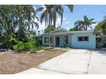 Charming single-story home with mature trees and a concrete driveway at 300 Westwinds Dr, Palm Harbor, FL 34683
