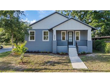 Charming blue two-story home with a welcoming front porch and landscaped front yard at 3902 E Henry Ave, Tampa, FL 33610