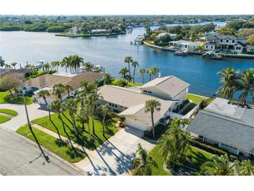 Waterfront home with lush lawn and palm trees on a sunny day in desirable neighborhood at 995 Eden Isle Ne Dr, St Petersburg, FL 33704