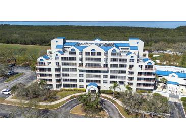 Stunning multi-story condo with blue accents, lush landscaping, and circular driveway at 2333 Feather Sound Dr # A308, Clearwater, FL 33762