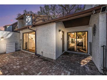 Charming exterior view of a home with a brick patio, stucco walls, and a well-maintained roof at 3456 Hunters Run Ln, Tampa, FL 33614