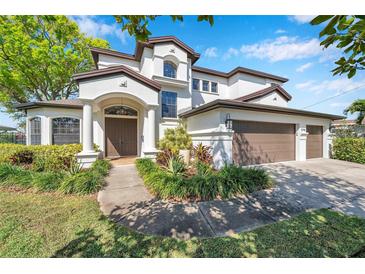 Elegant two-story home features manicured landscaping and a grand entrance with arched doorway and attached three-car garage at 3598 10Th Ne St, St Petersburg, FL 33704