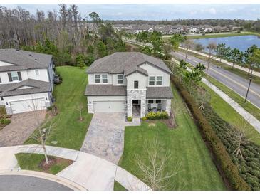 Stunning two-story home with beautiful landscaping, a paver driveway, and a stone facade at 3610 Aberdeen Gait Ct, Odessa, FL 33556