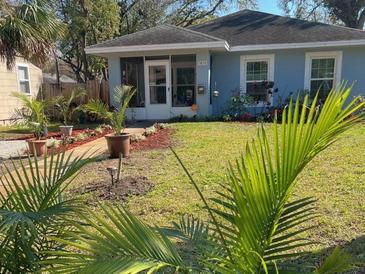 Landscaped home featuring lush lawn, palm trees and plants, walkway to screened porch at 3850 6Th N Ave, St Petersburg, FL 33713