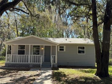 Charming single story home with a welcoming front porch and mature tree shading the property at 203 D Street, Brooksville, FL 34601