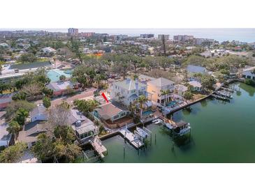 Waterfront home boasts a boat dock and lush landscaping near coastal scenery at 300 16Th Ave, Indian Rocks Beach, FL 33785