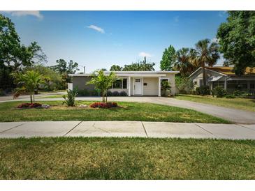 Charming single-story home with a well-manicured lawn, palm trees, and a long driveway on a sunny day at 4500 22Nd S Ave, St Petersburg, FL 33711