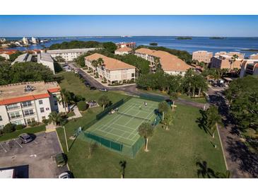 Aerial view of tennis courts and condo buildings surrounded by lush greenery at 611 Bella Loop, Dunedin, FL 34698
