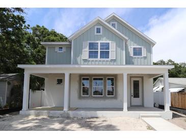 Charming two-story home with a covered front porch and light-blue siding, awaiting your personal touch at 615 48Th N Ave, St Petersburg, FL 33703