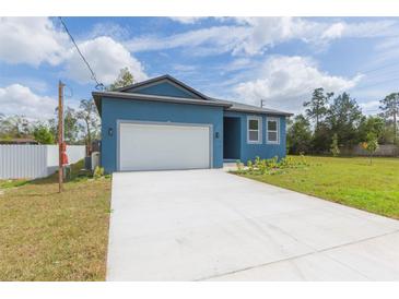 Bright blue single-story home featuring a two-car garage and well-manicured lawn at 9510 Xenia St, New Port Richey, FL 34654