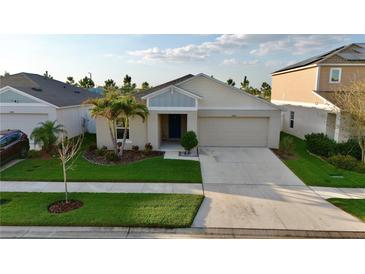 Charming single Gathering home features a well maintained lawn with lush landscaping and attached two car garage at 12820 Bent Twig Dr, Riverview, FL 33579