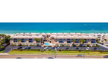 Stunning aerial view of beachfront condos with a pool, parking, and access to the beautiful ocean at 3100 Gulf Blvd # 134, Belleair Beach, FL 33786