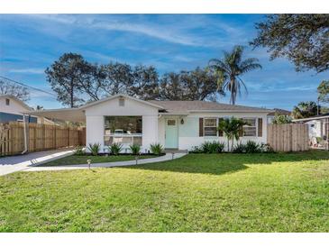 Charming single-story home featuring a well-manicured lawn, a carport and lovely landscaping at 3316 W Ballast Point Blvd, Tampa, FL 33611