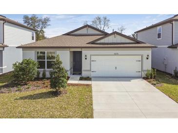 Charming single-story home featuring a two-car garage and well-maintained front yard with manicured landscaping at 4275 Big Sky Dr, Spring Hill, FL 34604