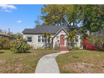 Charming bungalow-style home featuring a red front door, lush landscaping, and a curved walkway at 511 27Th N Ave, St Petersburg, FL 33704