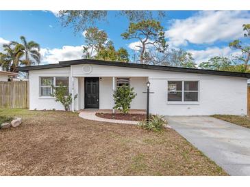 Charming single-story home with a well-maintained lawn, brick walkway, and black front door at 1316 Barry St, Clearwater, FL 33756