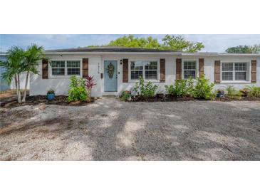 Charming home featuring a landscaped front yard and a light blue front door at 1415 54Th N Ave, St Petersburg, FL 33703