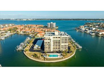 Stunning aerial view of the condominium with boat slips, pool, and beautiful landscaping at 1651 Sand Key Estates Ct # 53, Clearwater, FL 33767