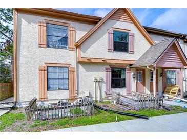 Charming multi-story townhome featuring a textured facade, complemented by light shutters, and a covered porch at 202 Brigadoon Dr, Clearwater, FL 33759