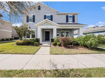 Charming two-story home with manicured lawn, lush landscaping, and welcoming covered entryway at 5027 Autumn Ridge Dr, Wesley Chapel, FL 33545